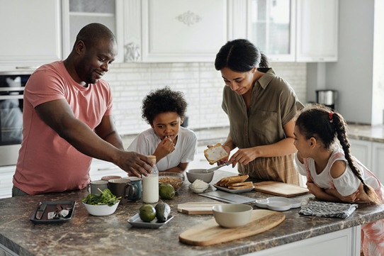 Family of 4 cooking together in kitchen