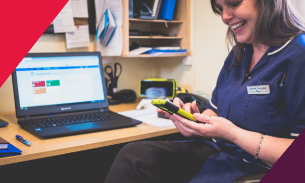A white female nurse looking at her phone smiling