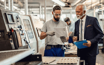 Manufacturing business man and factory worker talking